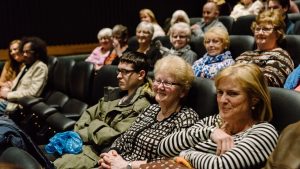 A smiling audience in a cinema auditorium