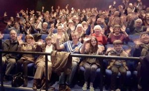 A cinema full of people waving