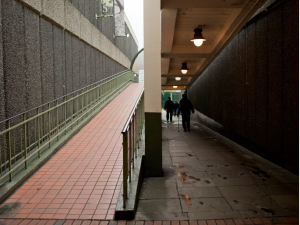 A view of a slope coming downwards and a dimly lit underpass outside.