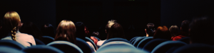 Photo of people sat down in the cinema facing a screen