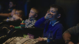 Boy eating popcorn watching film