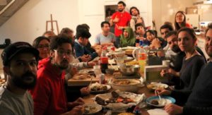 People eating dinner around a table facing the camera.