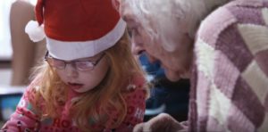 Older person drawing with a young person.