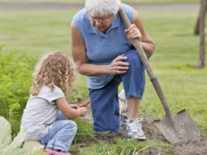 Older person gardening with a young person.