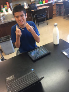 A young person with an i-pad gesturing with their hands