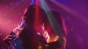 Still from A Fantastic Woman, a woman and a man dance closely under purple lighting.