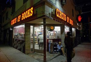 Still from the documentary “Circus of Books.” The street corner of the store Circus of Books lit up by the yellow lighting of it's shop sign.