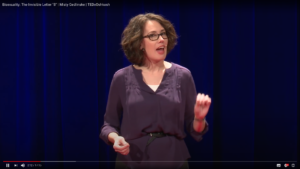 White woman speaks on TEDX stage