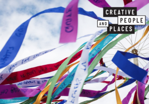 Screenshot from the front cover of Creative People and Places Network guide to Evaluation in Participatory Arts Programmes. Multi coloured ribbons with writing on them flying in the air