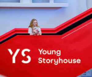 A young person standing on a big red staircase. White text says YS Young Storyhouse